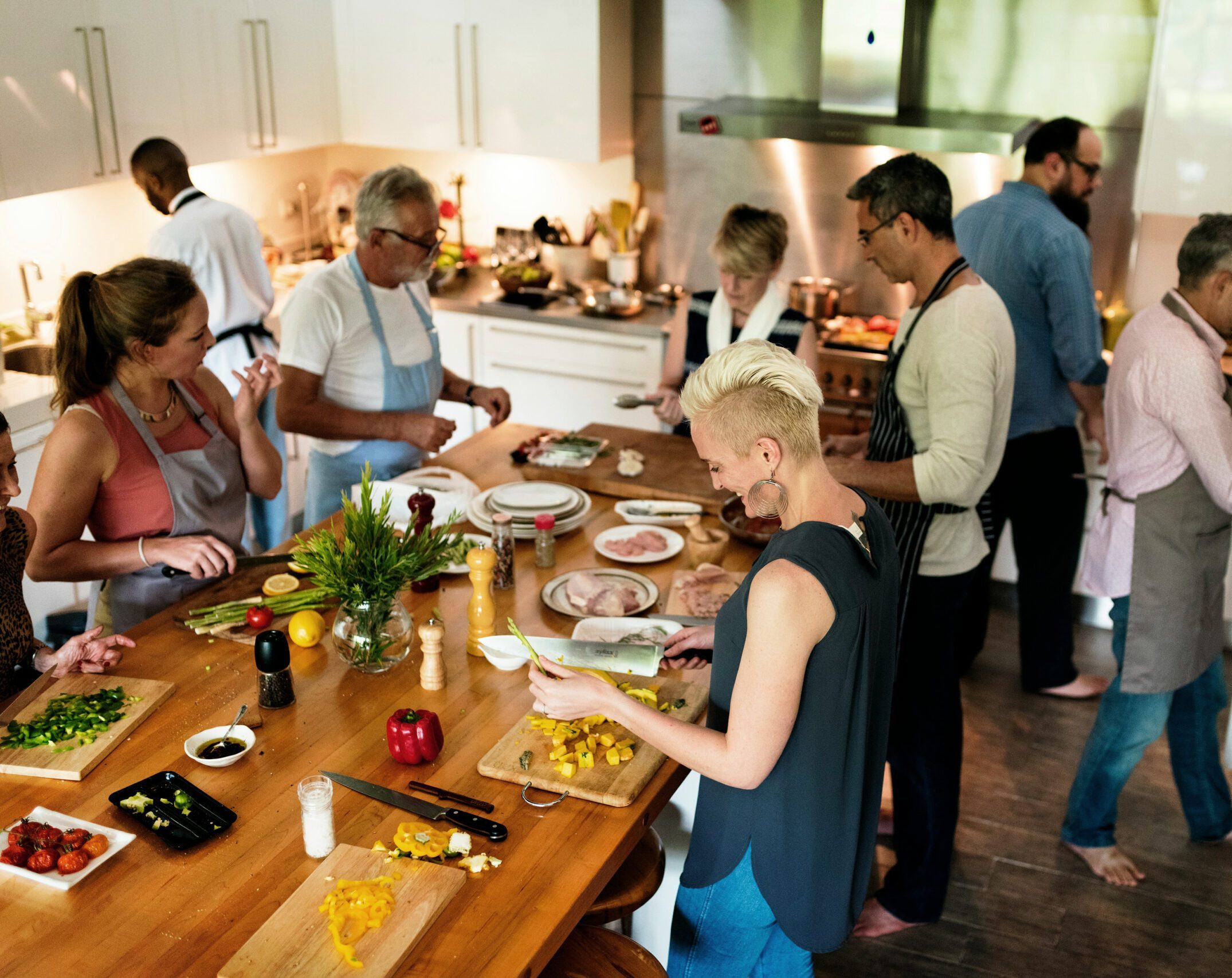 plusieurs personnes préparant à manger autour d'un îlot